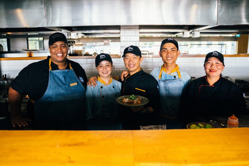 Crafting Captivating Headlines: Your awesome post title goes here A group of diverse chefs smiling and posing together in a modern restaurant kitchen.