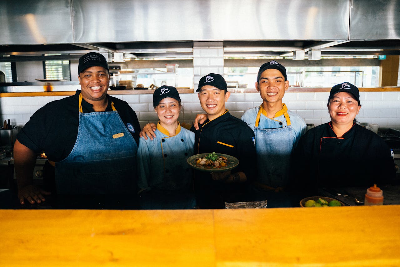 Crafting Captivating Headlines: Your awesome post title goes here A group of diverse chefs smiling and posing together in a modern restaurant kitchen.